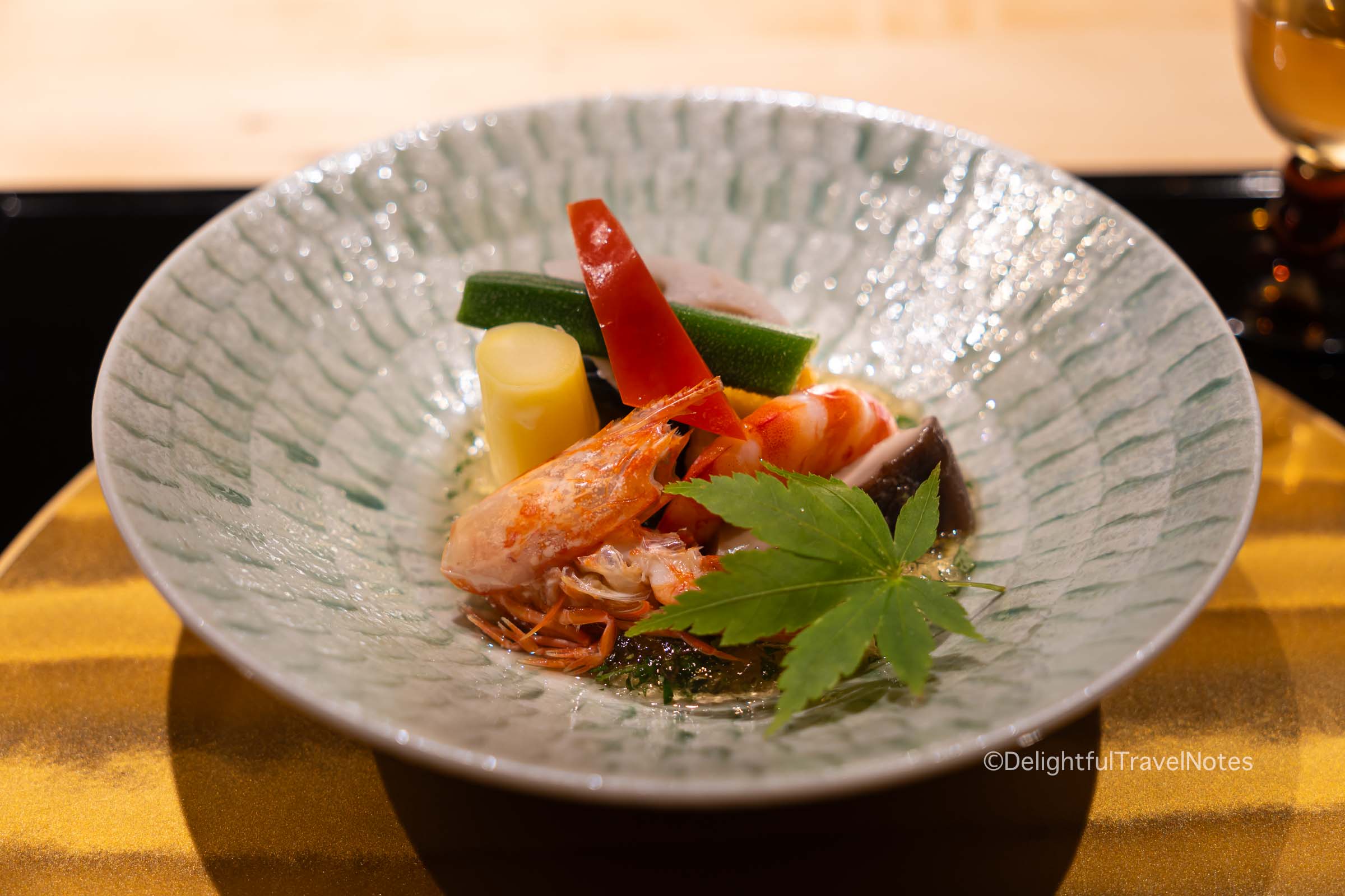 a plate of appetizer consisting of poached shrimp and vegetables in the kaiseki dinner
