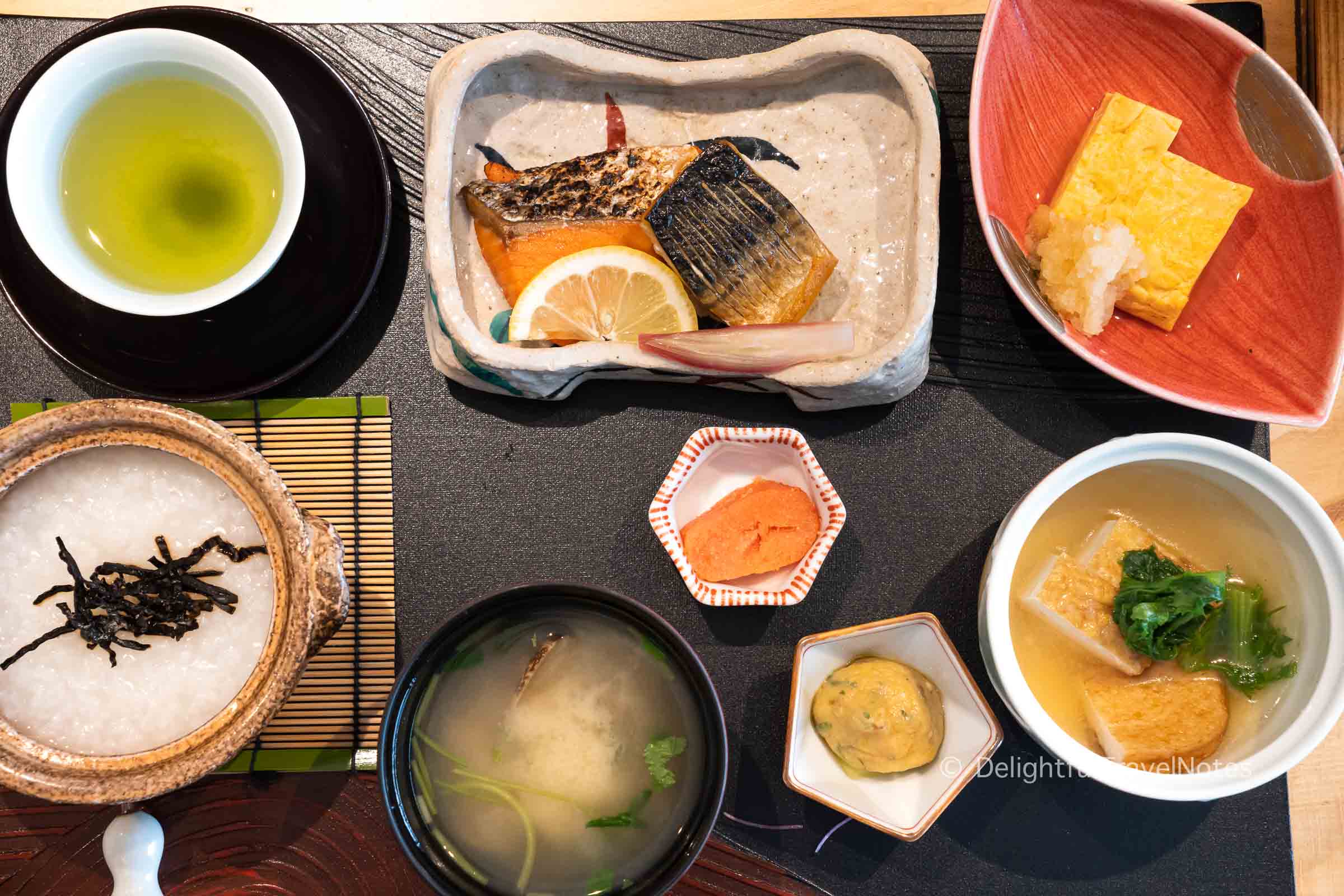 a tray of traditional Japanese breakfast at Madoka no Mori ryokan in Hakone with rice porridge, grilled fish, miso soup and tamagoyaki.