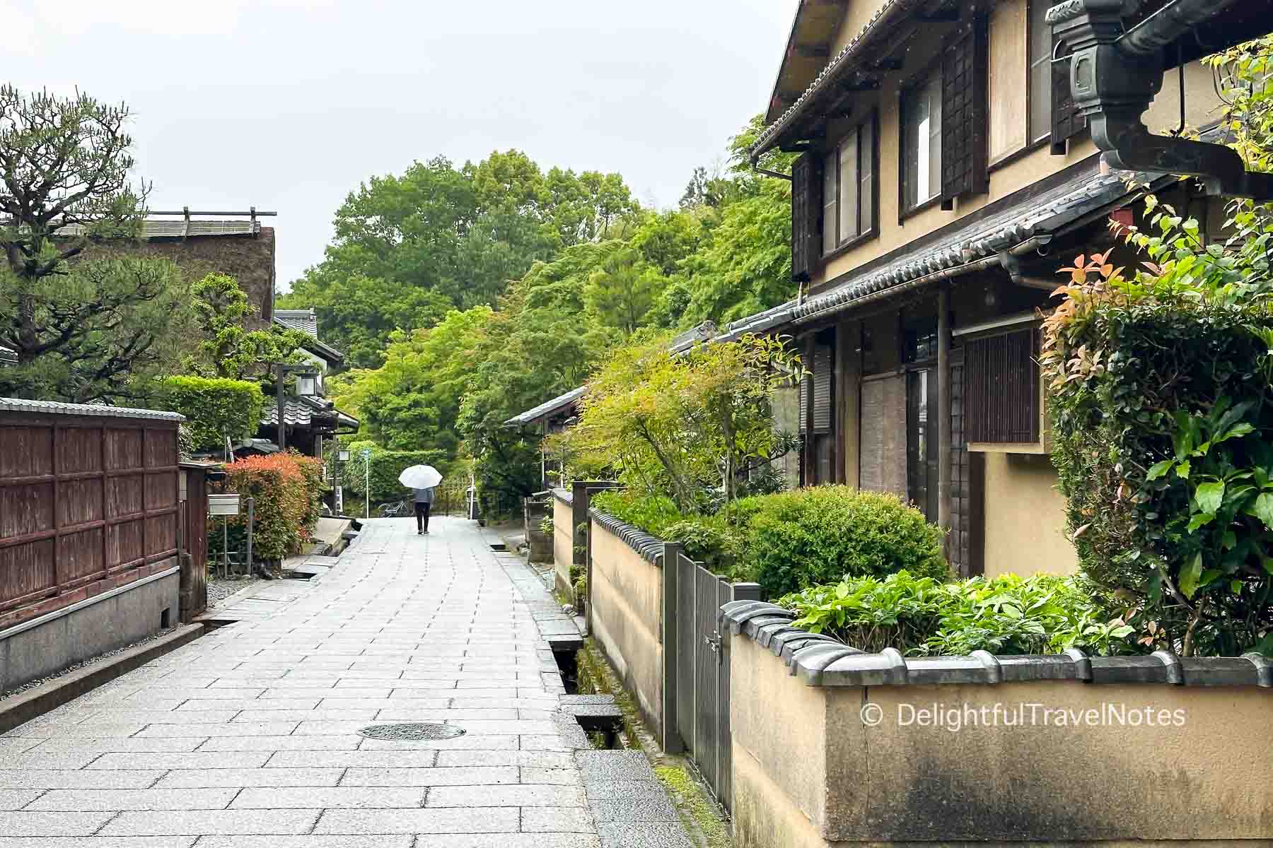 a walking path in Saga Toriimoto Preserved Street in Arashiyama with traditional wooden houses.