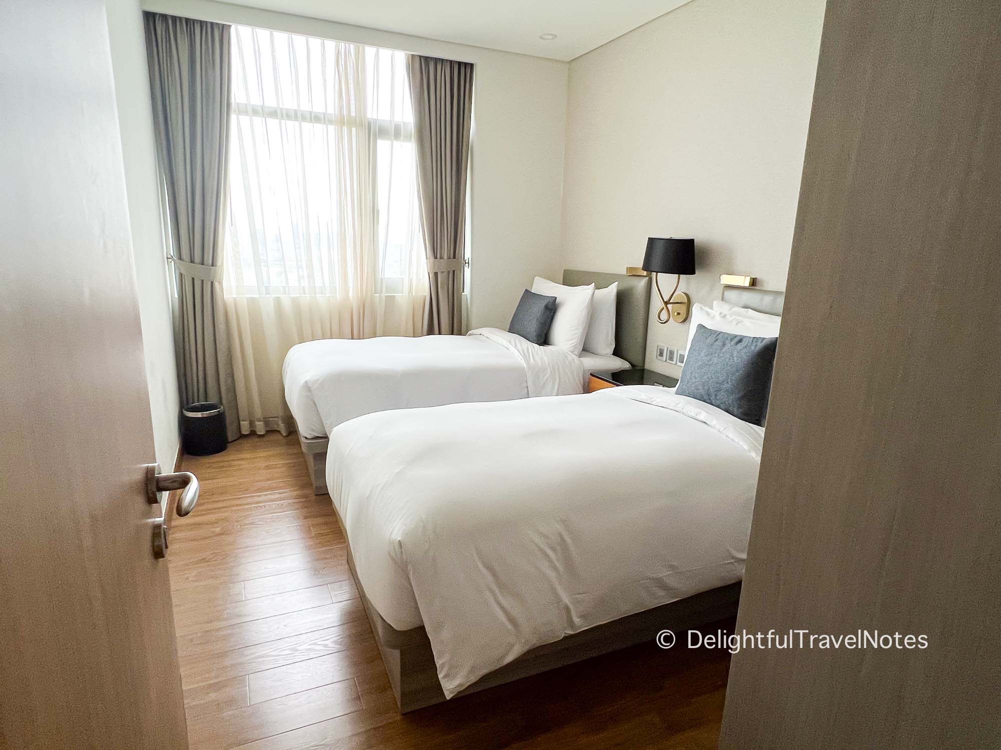a twin bedroom in a 3-bedroom apartment at Oakwood Residence Saigon.