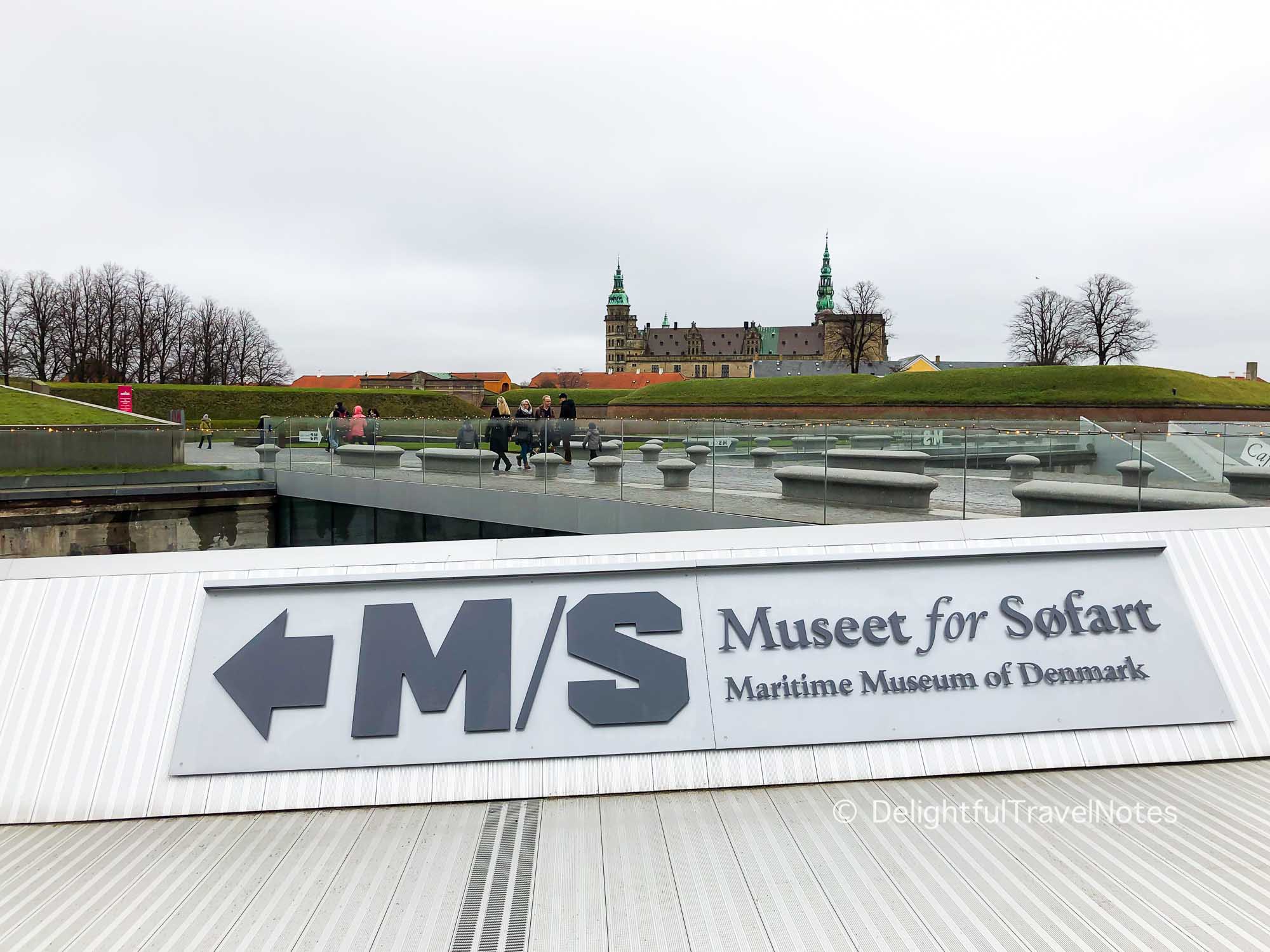 Sign of Maritime Museum of Denmark in Helsingor with Kronborg Castle in the background.