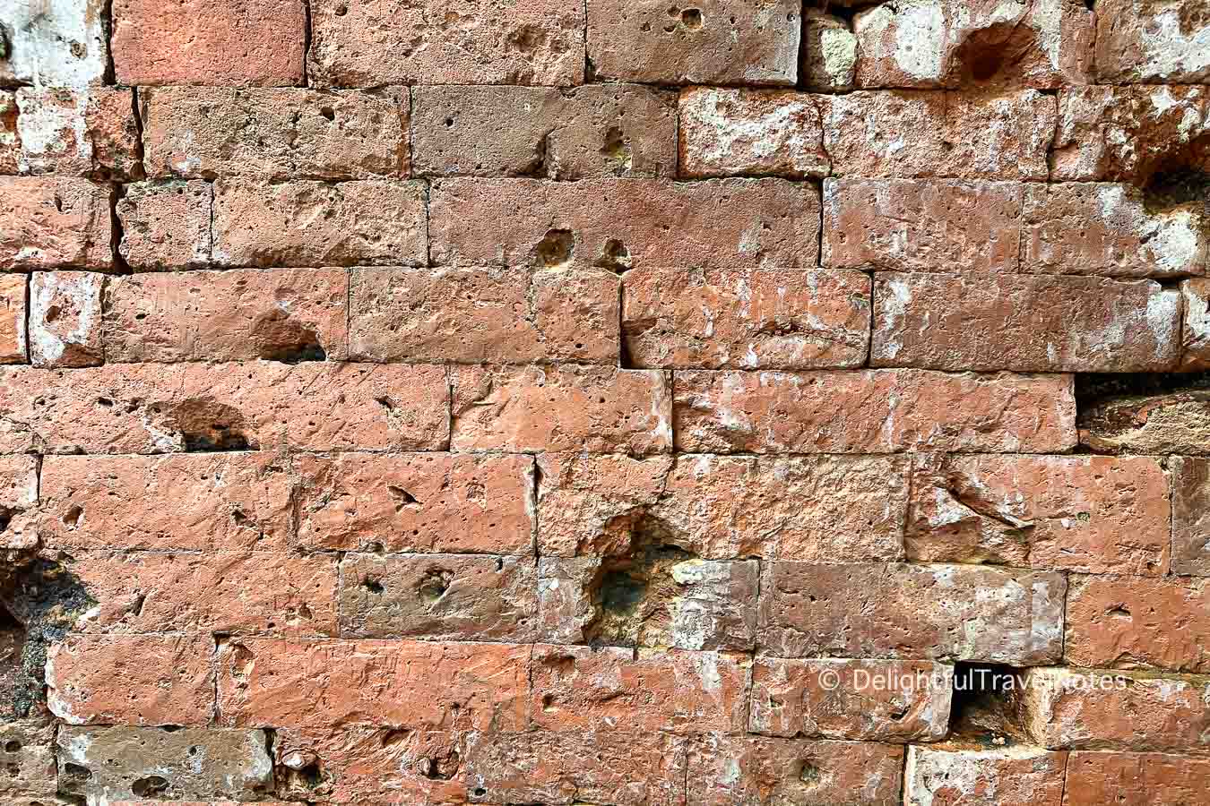 a wall with original ancient bricks at My Son Sanctuary.