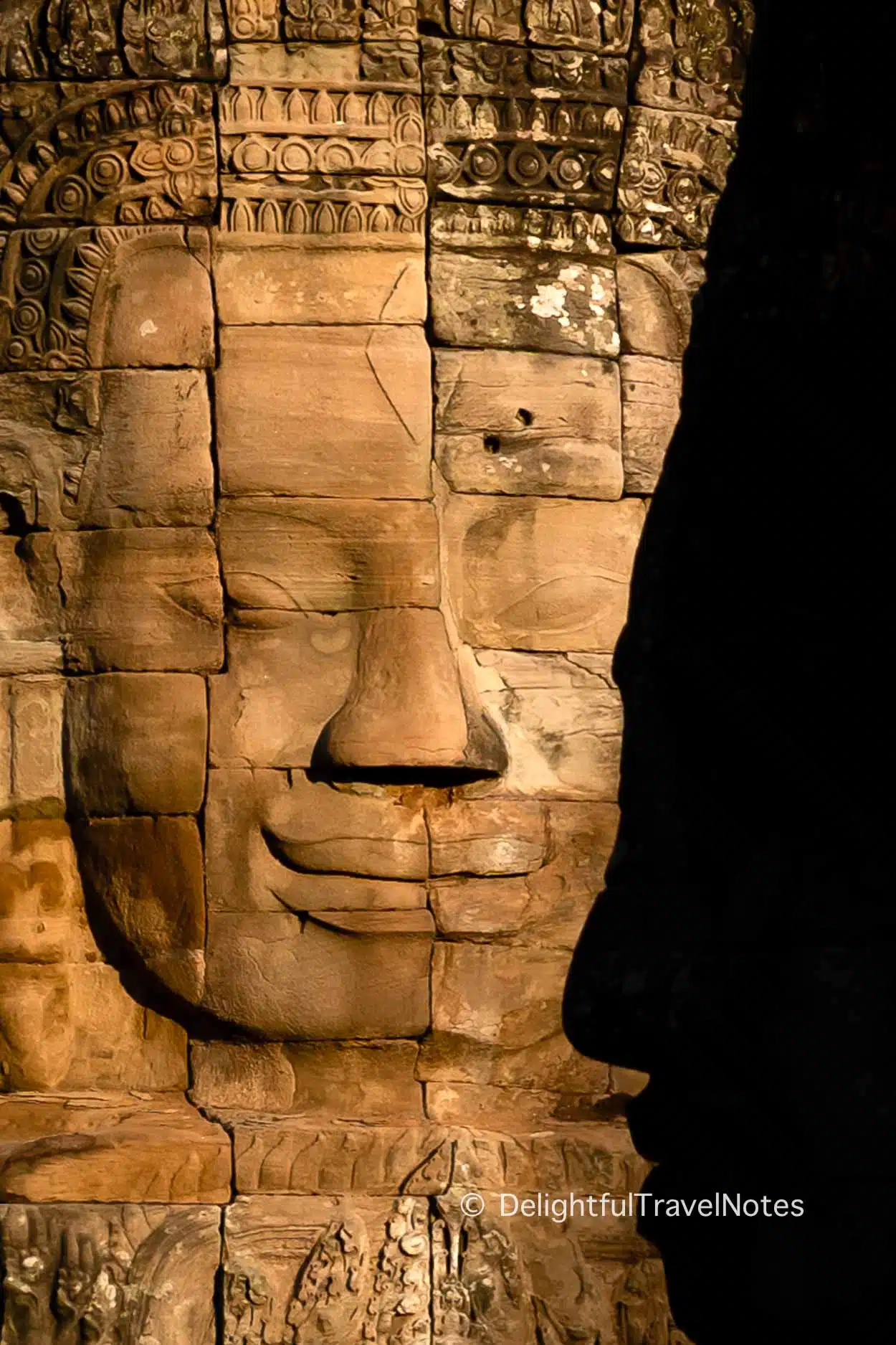 a smiling stone face at Bayon temple in Siem Reap.