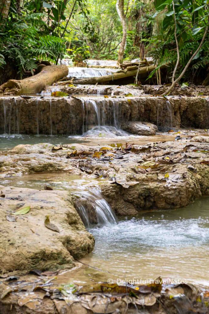 water cascading multiple tiers of Kuang Si Falls (Laos).