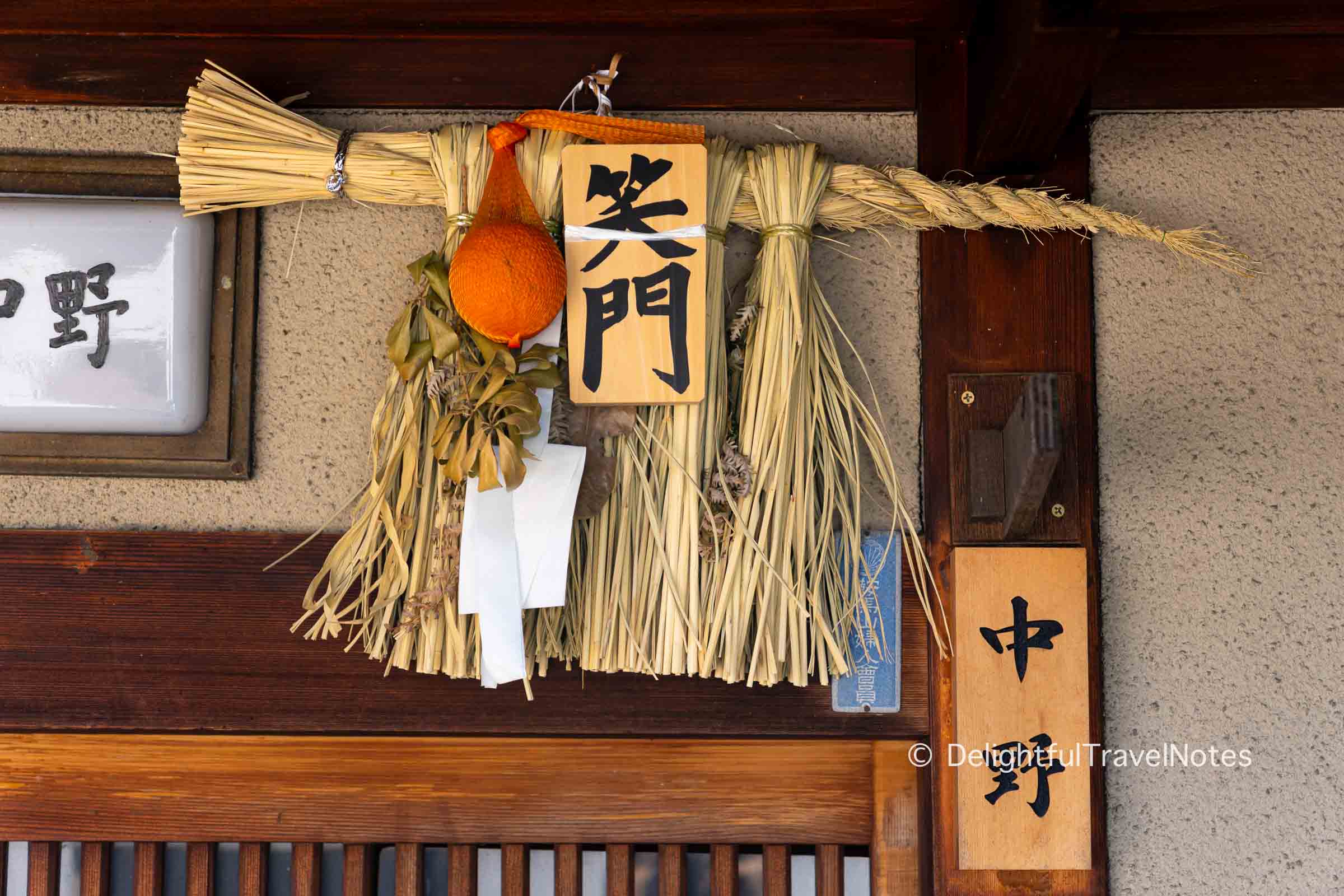 Shimenawa rice straw decoration with daidai (orange) hung over a door in Gion, Kyoto.