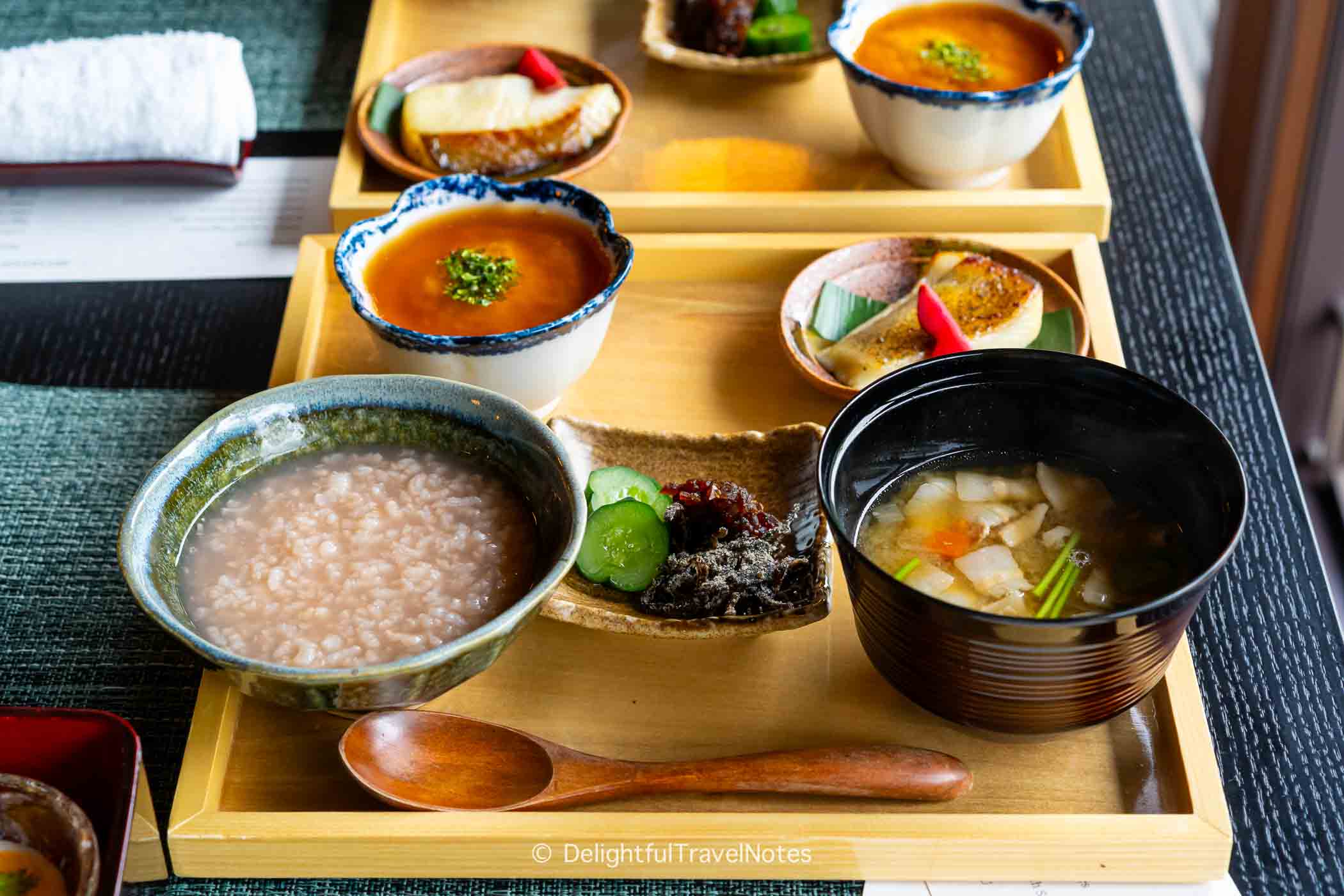 a tray with porridge, grilled fish, eggs, miso soup, and pickles for the breakfast at Shisui Nara.