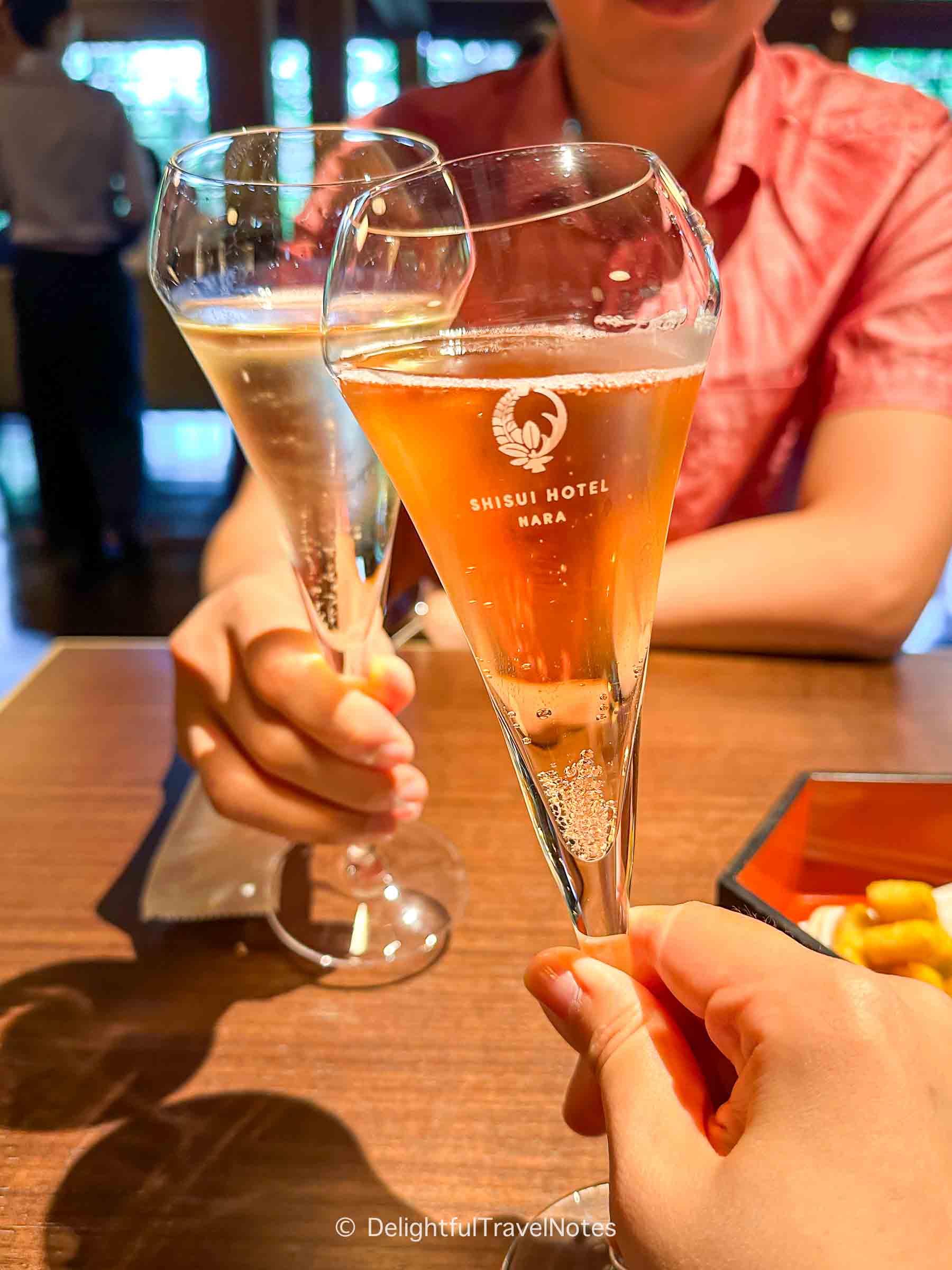 two hands holding two glasses of champagne during the happy hour at Shisui Hotel Nara.