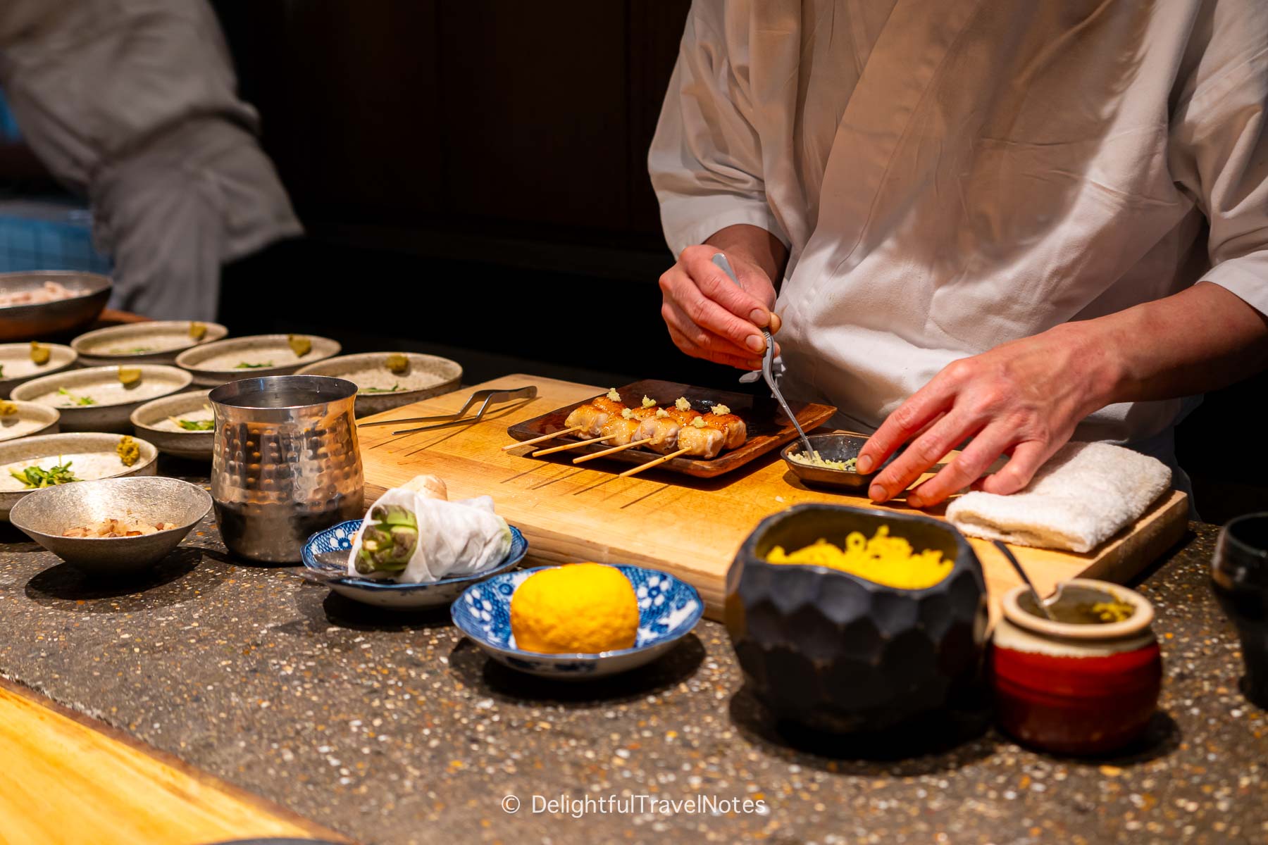 a chef preparing skewers for guests at Yakitori Taimatsu Osaka.
