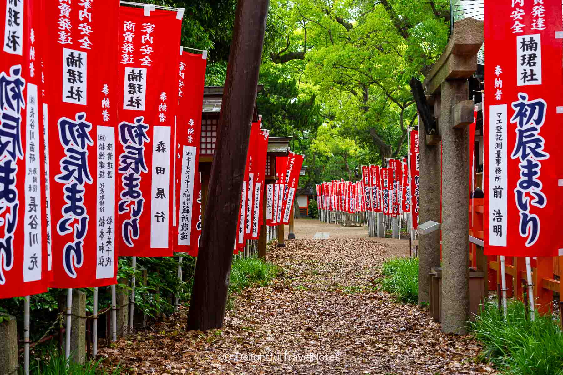 a path lined with red flags on the grounds of Sumiyoshi Taisha in Osaka.