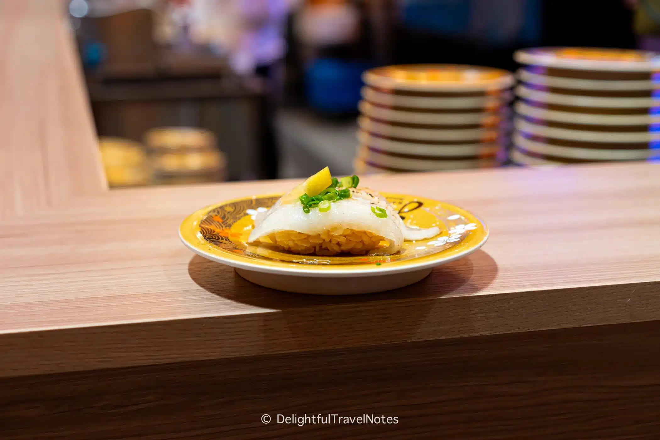 a plate of seared flounder fin nigiri at Kaiten Sushi Ginza Onodera in Osaka.