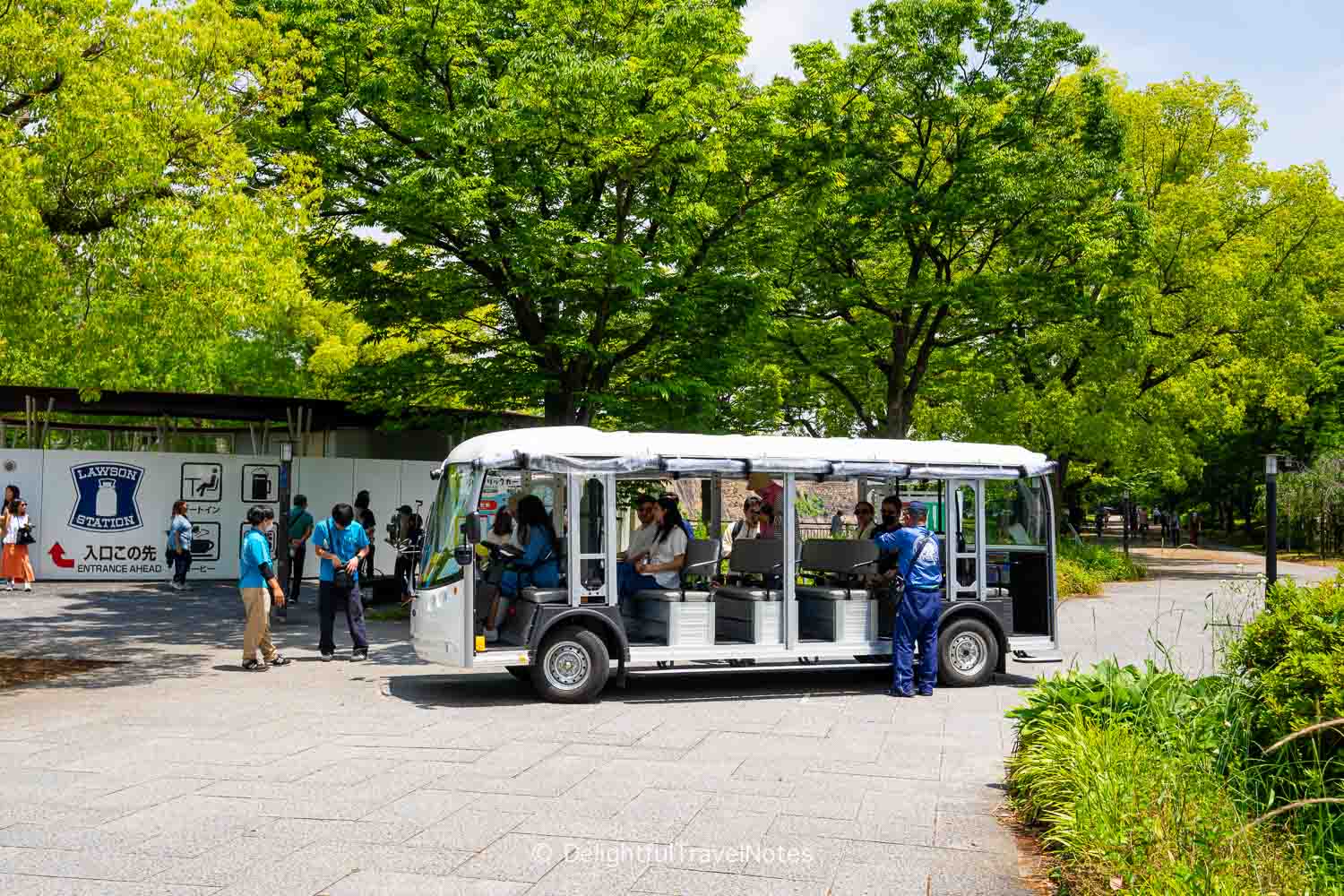 The mini shuttle around Osaka Castle grounds parking in front of a Lawson convenience store.