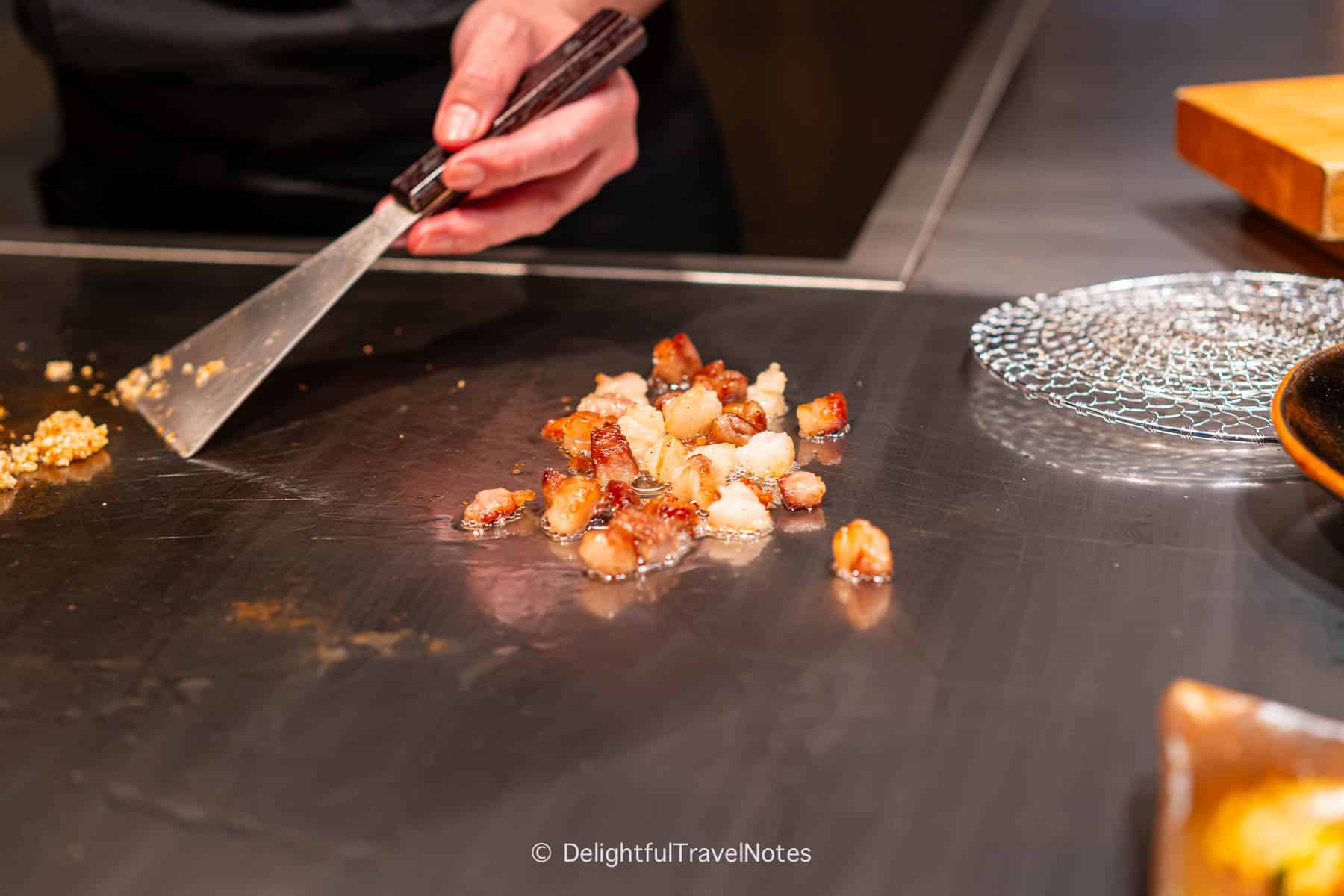 Beef trimmings and fat being rendered on the teppan.