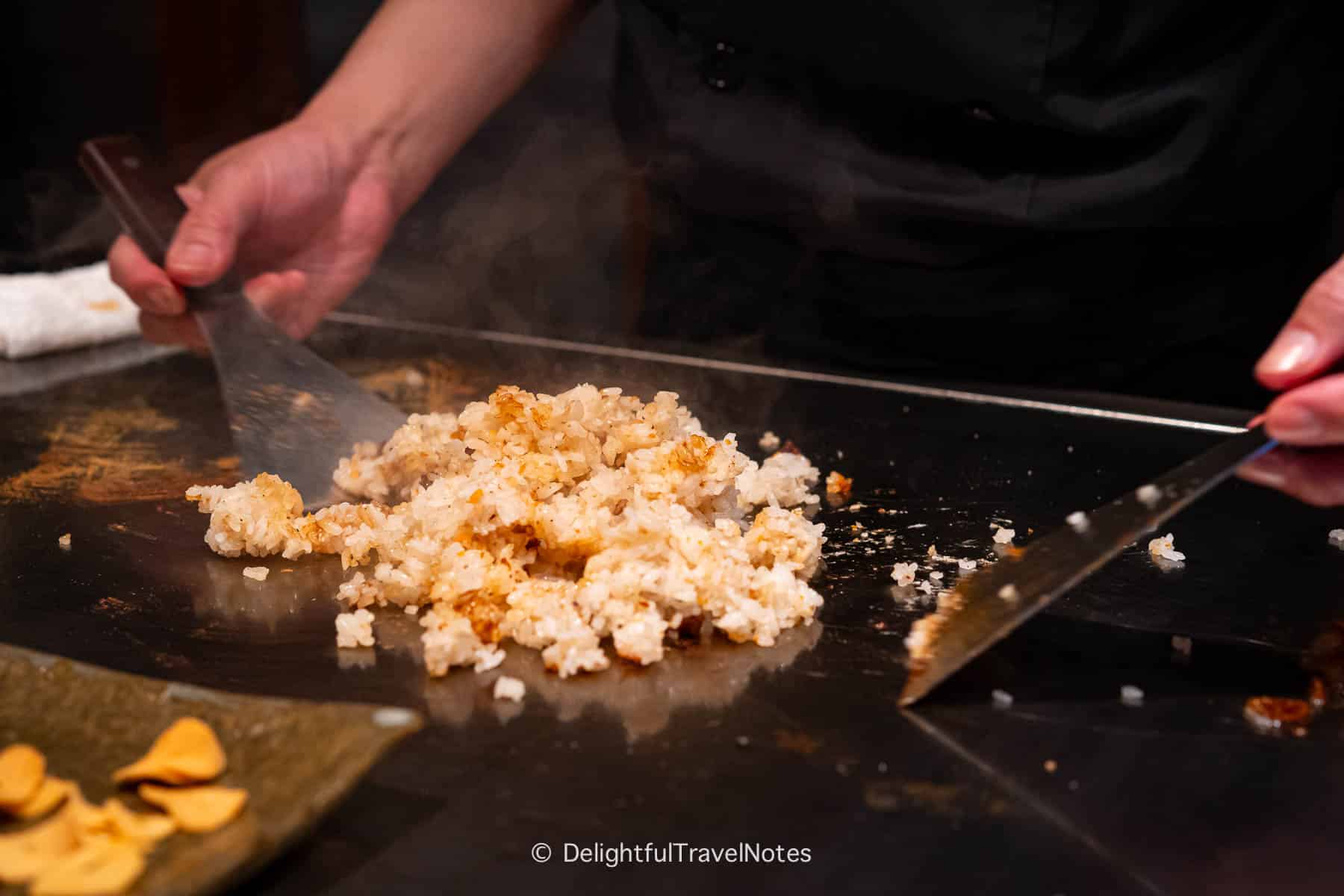 the chef cooking garlic fried rice on the teppan at Kobe Beef Steak Ishida restaurant.