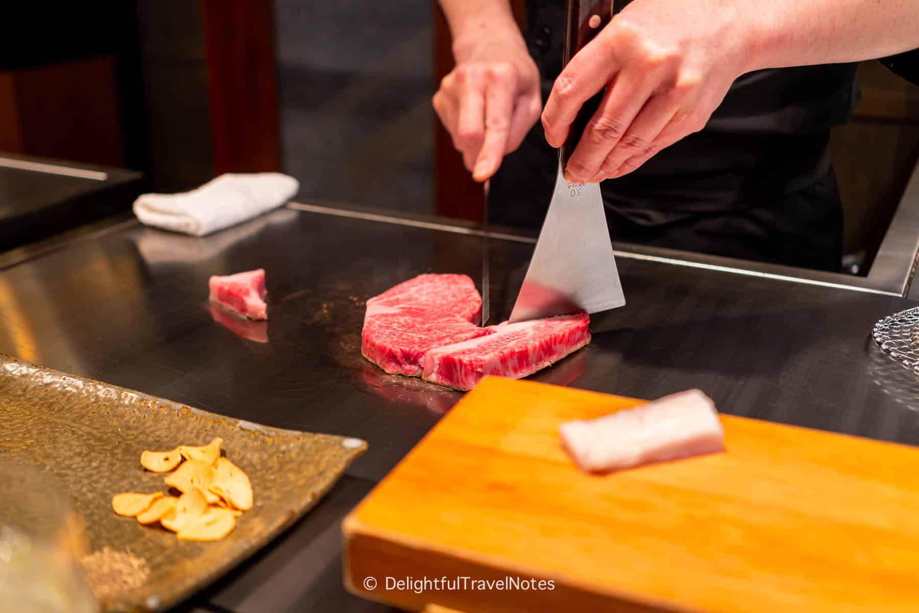 Chef separating beef on the teppan in Kobe Beef Steak Ishida restaurant.