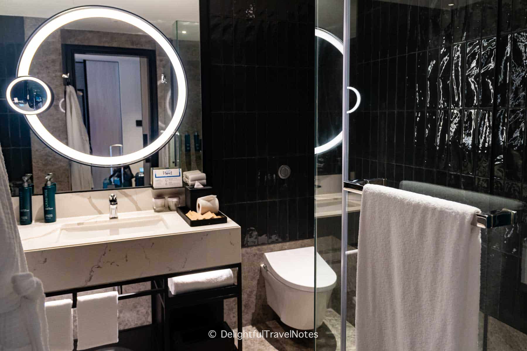 Hilton Singapore Orchard bathroom with vanity, toilet and shower cubicle.