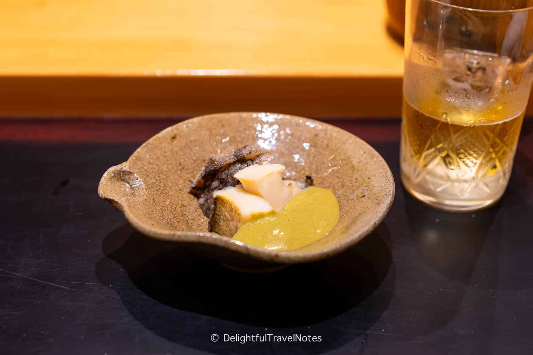 a plate of abalone with liver sauce in the affordable omakase at Sushi Issei in Kanazawa.