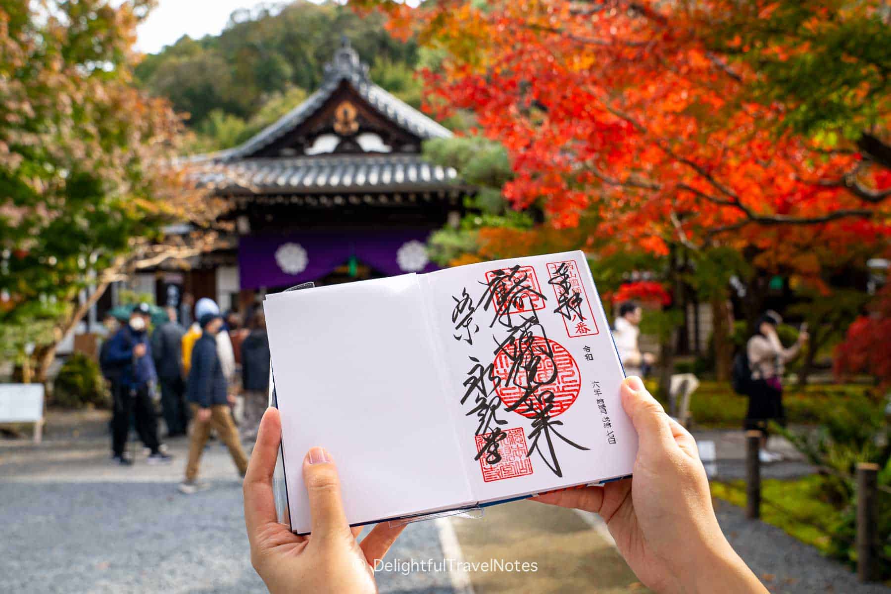 Goshuin of Eikan-do temple in Kyoto with fall colors in the background.