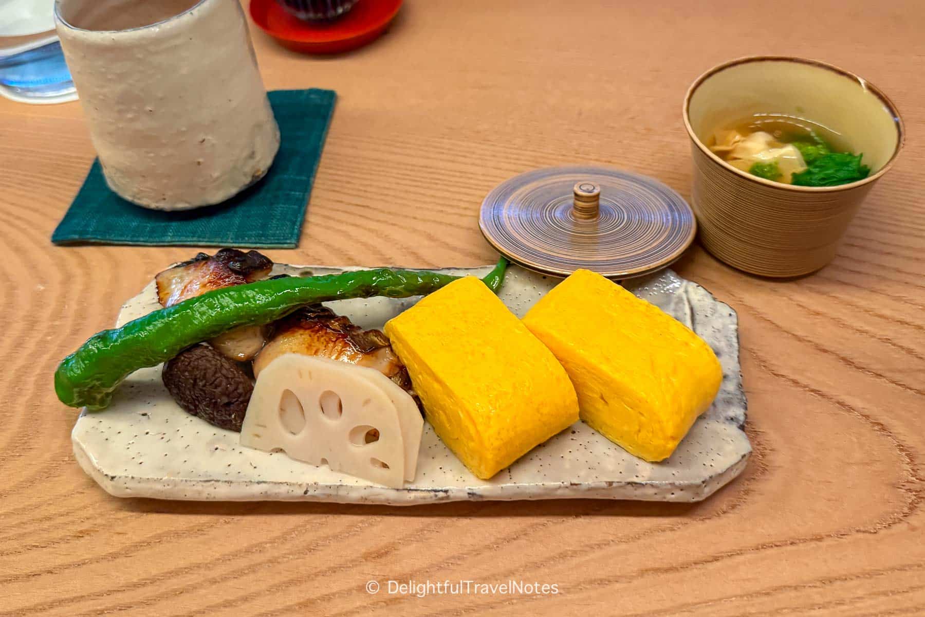 a plate with grilled fish and tamagoyaki in Japanese breakfast at The Hiramatsu Kyoto.